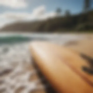 Surfboard resting on the beach with waves in the background