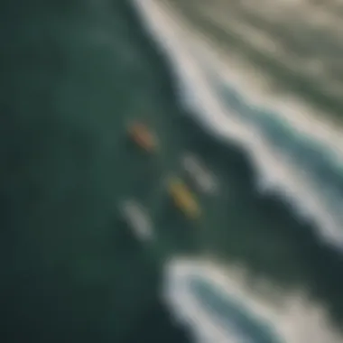 An aerial view of a group of surfers paddling together in the ocean.