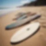 Various skimboards displayed on a sandy beach