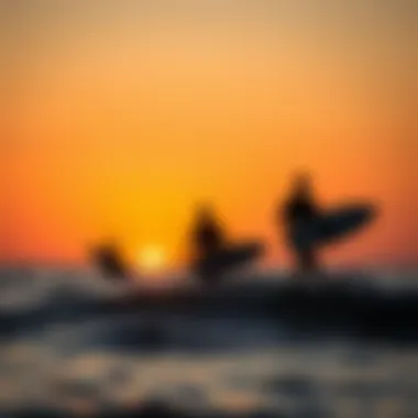 Sunset over the ocean with surfers silhouetted