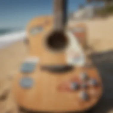 A close-up of a guitar with surf-themed stickers and a sandy beach background.