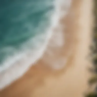 An aerial shot of a pristine beach with waves crashing on the shore.