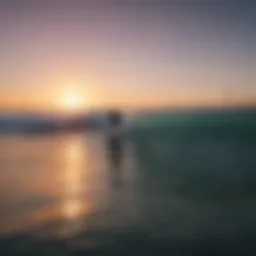 Surfers riding waves at sunset