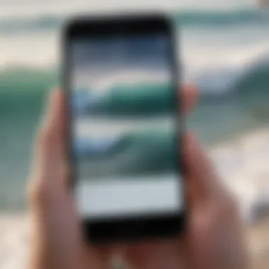 Close-up of a surf report displayed on a smartphone with ocean waves in the background