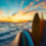 A vibrant sunset over the ocean with surfboards lined on the shore