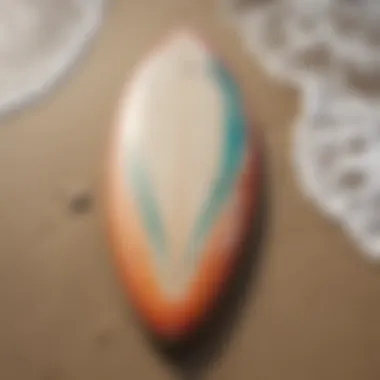 Close-up of a surfboard on the sand with waves in the background