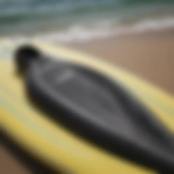 Close-up of a surfboard with neoprene wetsuit draped over it