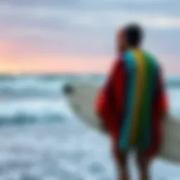 Surfer in a vibrant towelling poncho by the ocean