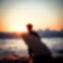 A surfer contemplating the waves at sunrise.