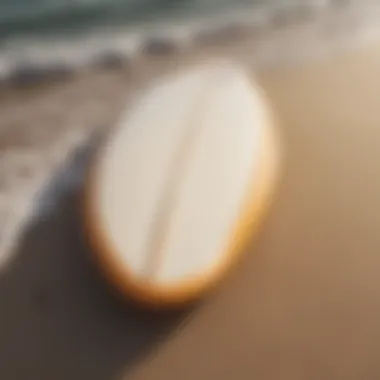 Close-up of surfboard on the sand, reflecting the ocean waves.