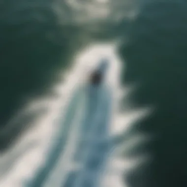 An aerial view of a wakesurfer riding a wave created by a boat